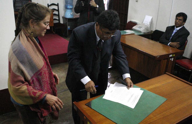 Lori Berenson prepares to sign documents yesterday in a Lima, Peru, court.