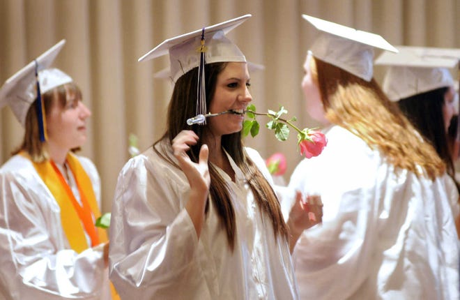 Graduating senior Nora Donahue clenches a rose in her teeth before the start of the St. Peter-Marian graduation at Mechanics Hall last night.
