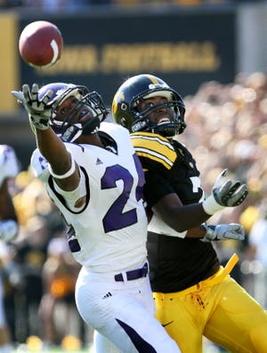 Northwestern's Sherrick McManis, left, breaks up a pass intended for Iowa's Marvin McNutt during the first half Saturday in Iowa City, Iowa. McManis, the former Richwoods standout, and the Wildcats knocked off the previously unbeaten Hawkeyes 17-10.