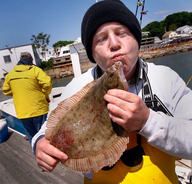 Glenn Verdini of West Boylston makes friends with a Quincy Bay flounder he caught, in Houghs Neck, Quincy. QHoughs Neck was once called the flounder fishing capital of the world, and after years of decline due to pollution the fishing has come back to Quincy.