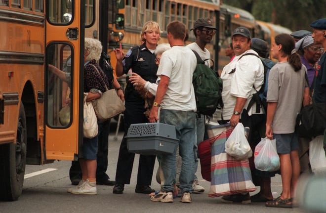 A police officer assists evacuees before Hurricane Floyd in 1999. When a mandatory evacuation is ordered, Chatham Area Transit buses will take those without their own vehicles to the Savannah Civic Center. At the Civic Center, people will be organized by need and loaded onto school buses and taken to inland shelters. Savannah Morning News file photo