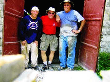 From left, the Rev. Dana Hayden, Bill Stoermer and Bill Critchfield pose for a photo while rebuilding a damaged building.