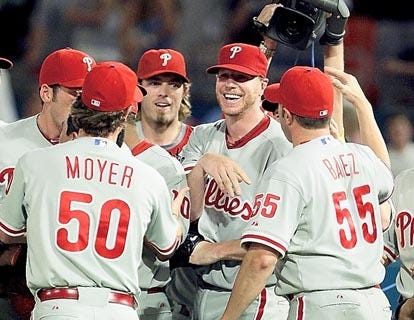 Philadelphia Phillies starting pitcher Roy Halladay, second from right, is mobbed by teammates after throwing a perfect game against the Florida Marlins on Saturday in Miami. AP Photo