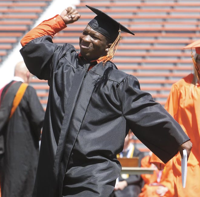 Washington High School 2010 graduate Terry Yarnell Moore pumps his fist to the crowd at Paul Brown Tiger Stadium after receiving his diploma during Sunday’s commencement ceremony.