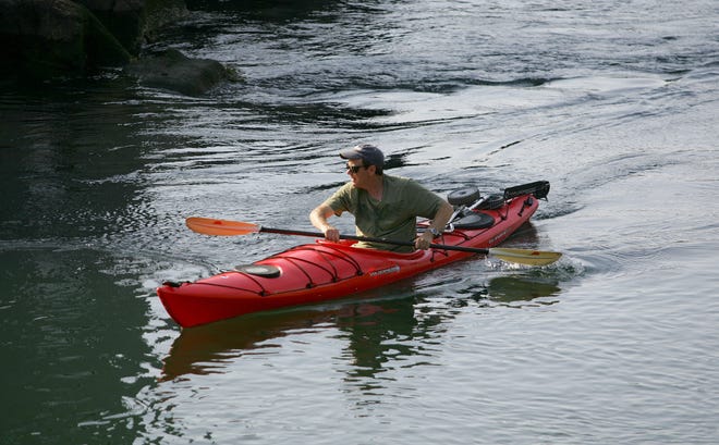A kayaker glides across the waters of Cohasset Cove on Wednesday afternoon.