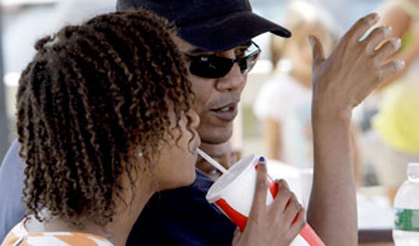 President Barack Obama relaxes with daughter Malia in Oak Bluffs last August. The family may visit again this summer.