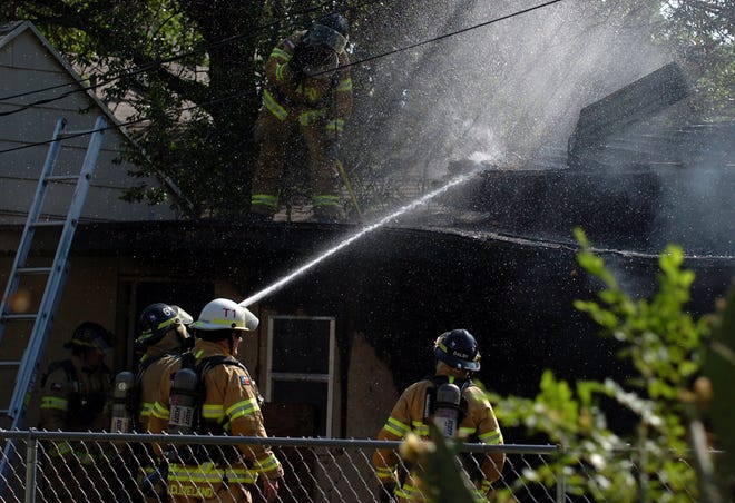 Lubbock firefighters knock out hot spots on a fire in the 1500 block of 25th street on Thursday in Lubbock. (Zach Long)