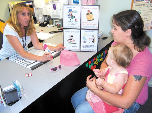 Heather Aldred, left, RN and WIC/casemanagement nurse with the Henry and Stark County Health Departments, educates client Kerry Bell and her daughter Kadynce on sun safety measures. The health department staff is noting National Sun Safety Week, June 6-12, and educating area families on skin cancer prevention and sun protection.