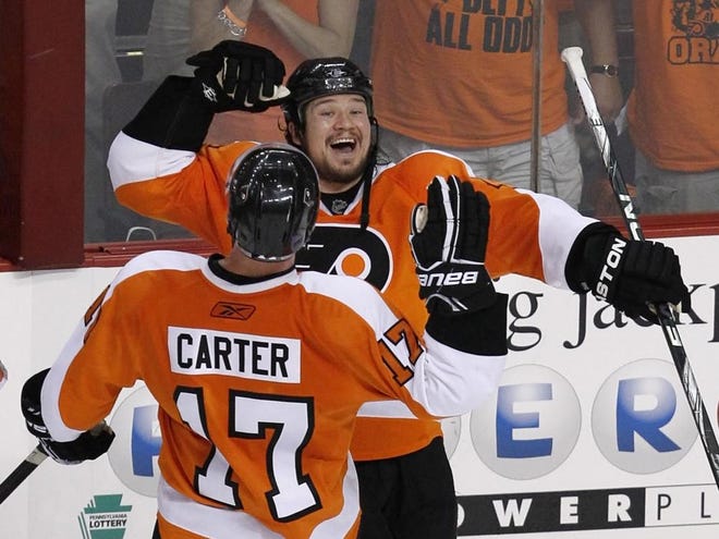 Philadelphia Flyers right wing Arron Asham, right, celebrates with center Jeff Carter (17) after the Flyers defeated the Chicago Blackhawks in Game 4 of the NHL Stanley Cup hockey finals on Friday. The Flyers won 5-3 to even the series 2-2.