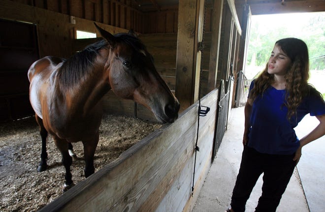 Anastasia Megan visits her horse, Duke, at her family's stable in Center Hill. The 13-year-old is trying to enroll in college.
