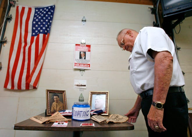 Mel Schlabach, who was recognized as the Veteran of the Year in 2009, looks at mementos of the late Bennie J. Angelo at the VFW Post 3747 Sunday. Angelo's murder remains unsolved. Schlabach is also a committee member on the foundation that bears Angelo's name.