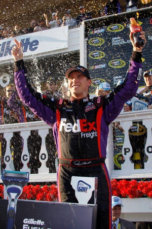 Denny Hamlin celebrates in victory lane after winning the NASCAR Sprint Cup Series auto race, Sunday, June 6, 2010, in Long Pond, Pa. (AP Photo/Russ Hamilton Sr.)