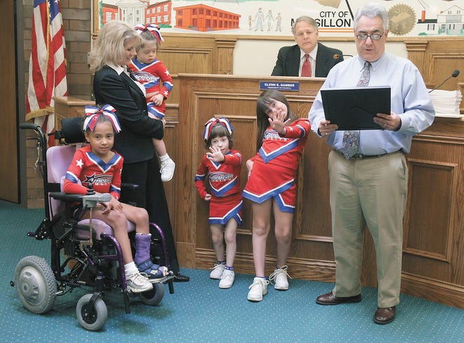 Massillon Mayor Frank Cicchinelli reads a proclamation to members of the American Idols cheer team of Massillon. From left are Elizabeth Browns, Councilwoman and coach Kathy Catazaro-Perry, Vanessa Perry, Victoria Garner and Jasmine Garner. Also honored were Katie Teets, not pictured, and the late Sydney McInnis.