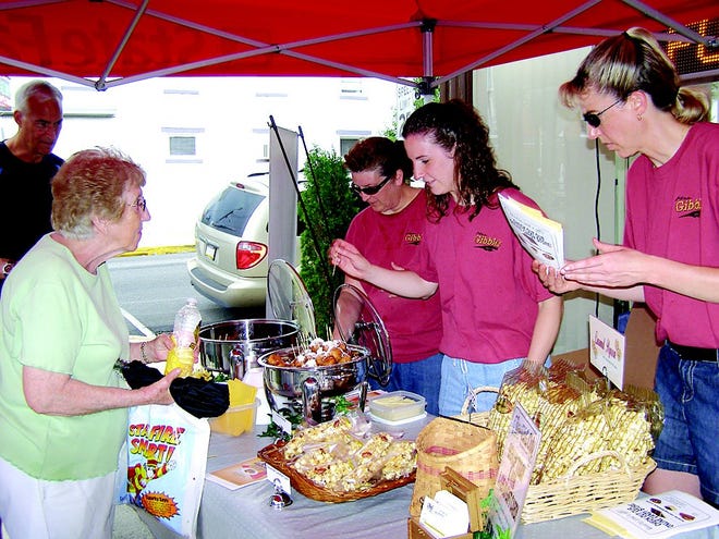Kim Eshleman, Aimee Eshleman and Angie Gaido hand out samples of corn fritters, pork tenderloin and caramel corn, courtesy of Mrs. Gibble’s Restaurant, during First Friday. Helen Hager visited their booth on Center Square. The monthly event is sponsored by the Greencastle Area Arts Council and Greencastle-Antrim Chamber of Commerce.