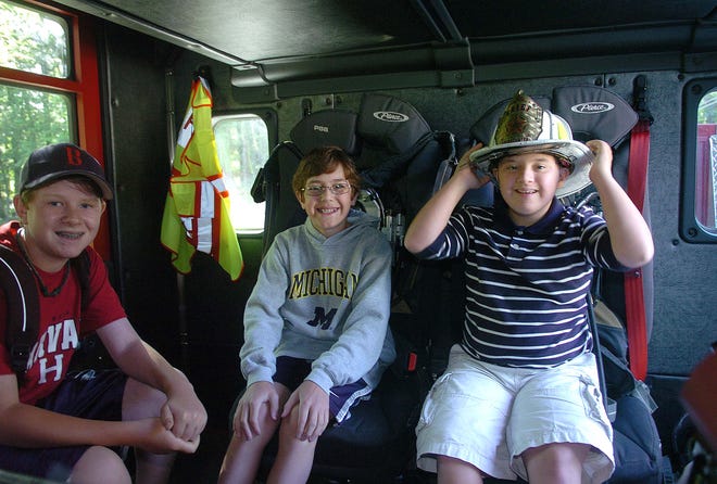 Brian Palmieri, 12, right, and his two friends Joey Rindini, 12, left, and Dylan Mazzarella, 11, get a ride to the Williams School in Bridgewater with the assistance of Fire Chief George Rogers.