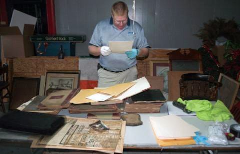 Grand Knight Walt Harper inspects a document at the Knights of Columbus Savannah Council 631's historical home at 3 W. Liberty St.