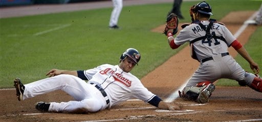 Cleveland Indians' Trevor Crowe, left, tags home plate and scores as Boston Red Sox catcher Victor Martinez is late on the tag in the first inning in a baseball game on Wednesday, June 9, 2010, in Cleveland. Crowe scored on a sacrifice fly by teammate Jhonny Peralta.