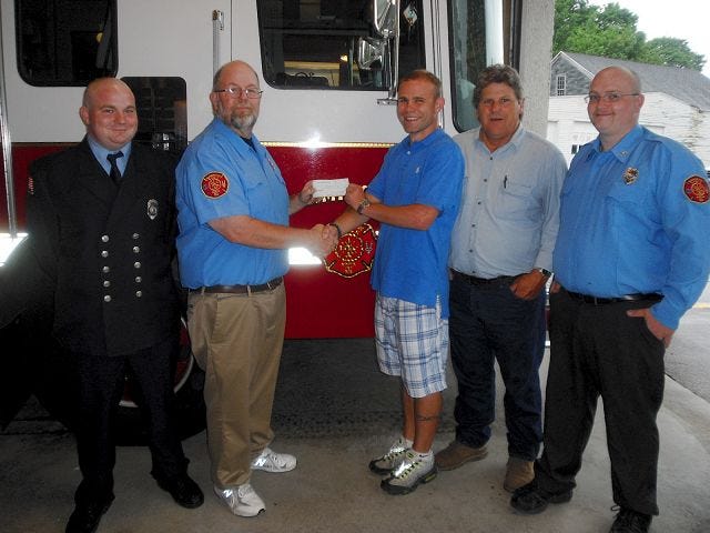 O'Donnell/Democrat photo 
The Farmington Fire Relief Association presents Farmington Recreation Director Rick Conway, center, with a check for $1,000 that the association raised to cover a deficit for the Hay Day fireworks display. From left are: Mike Sproul, fire association vice president; Rick Gladding, president; Conway; Scott Norton, association member; and Bryan Aube, association member.