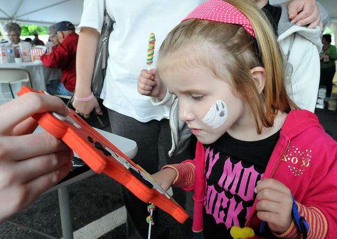 Grace Healy-O'Niel, 4, of Millbury, checks out her face painting during the Cancer Survivorship "Under the Big Top" celebration in Milford, Thursday.
