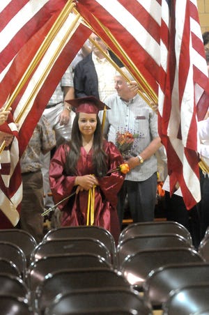 Class Vice President Alisia Trevino of New Bedford, a large animal science major, processes under the flags at the start of graduation.
