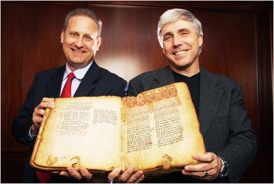 Steve Green, left, president of Hobby Lobby, and Scott Carroll, director of the Bible museum, with a copy of the Ethiopic Gospels.