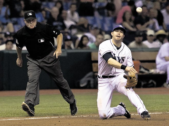 Umpire Jim Joyce, left, watches as Tampa Bay third baseman Evan Longoria makes a throw from his knees on a ground ball hit by Florida's Mike Stanton on Saturday in St. Petersburg.