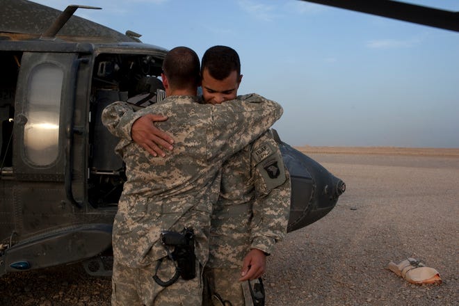 Sgt. Grayson Colby, a crew chief, left, and flight medic Sgt. Ian Bugh hug 
after a medevac mission at Camp Dwyer in Helmand province, Afghanistan.NEW 
YORK TIMES / TYLER HICKS