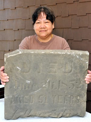Somboon "Kat" Waldren said people working behind her home discovered a gravestone buried in the ground near a concrete walkway. The stone was dated 1852, but no name was on it.