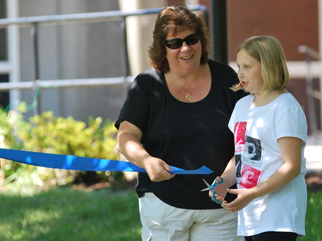 Parent Cindy Trillcott helps her daughter Amy cut the ribbon to officially open Lincoln-Hancock Community School's reading garden Tuesday.