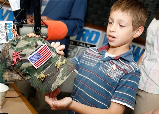 David Morales, 8, from Coventry, R.I., shows his decorated army hat during an appearance on WPRO-AM's John DePetro radio show in East Providence, R.I., Friday, June 18, 2010. The Rhode Island boy whose school banned the hat he made because the toy soldiers on it carried guns has been awarded a medal for his patriotic efforts. Lt. Gen. Reginald Centracchio, adjutant general emeritus of the Rhode Island National Guard, gave Morales the medal Friday. He also gave him a certificate that allows David to call himself a brigadier general.