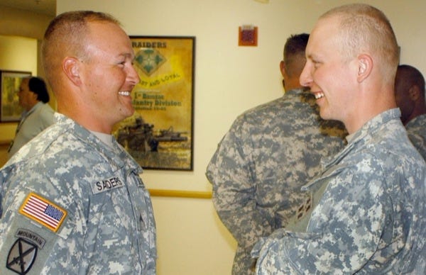 Cpl. Joe Sanders, left, and Spc. Albert Godding talk earlier this year at Fort Polk, La., before Godding received a Meritorious Service Medal for preventing Sanders' suicide in 2008.