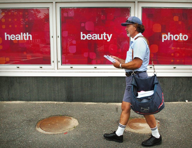 Ken DeLuca, a USPS letter carrier, delivers mail along his Wollaston route on June 16, 2010. DeLuca has been delivering mail in Quincy since age 18 when he became a Postal Carrier right after graduating from North Quincy High School.