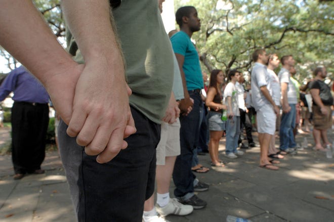 Supporters hold hands in unity as they sing during a GLBT Equal Protection Protest Rally Sunday in Johnson Square. The rally was held in response to the June 12 beating of Kieran Daly. Richard Burkhart/Savannah Morning News