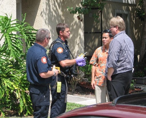 A Jacksonville firefighter (center) holding a meter in his gloved hands and wearing an air tank with mask speaks with investigators before heading into a Mandarin apartment where a suspicious powder was found in the mail June 7. The powder turned out to be crushed silica beads