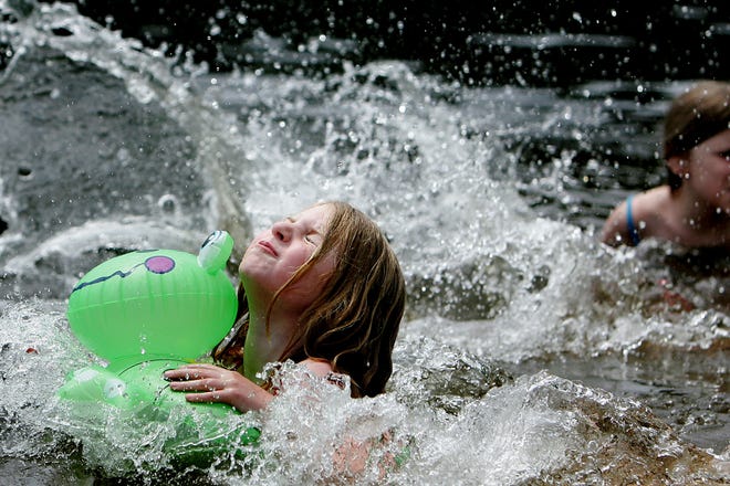 Abby Tucker, 6, of Bellingham tries to keep her head above water while splashing around with her flotation toy during a trip to Arcand Pond in Bellingham on Tuesday.