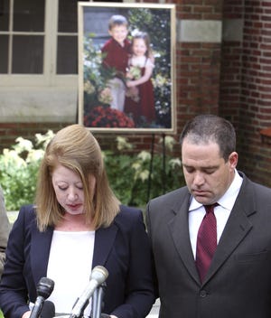 David Sochat, right, listens as his wife Debra, sister of Laura Stone Mortimer of Winchester Mass., who was killed along with her mother and two children allegedly by her husband Thomas Mortimer IV, reads family statement, Tuesday, June 22, 2010, in Winchester. Police found the bloodied bodies of Stone Mortimer, her two children, 2-year-old Charlotte and 4-year-old Thomas Mortimer V and her mother Ellen Stone, in their Winchester home last week.