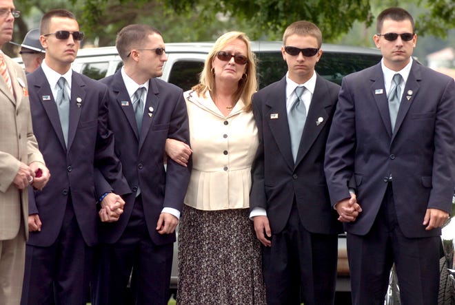 Judy Weddleton, the wife of state police Sgt. Douglas A. Weddleton, who has killed on Interstate 95, waits with her four sons as the honor guard brings her husband’s casket into Our Lady of Lourdes Church in Brockton on June 23, 2010. From left are sons Ross, 18; Stephen, 26; Matthew, 14; and Mark, 23.