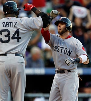 Dustin Pedroia (right) is congratulated by David Ortiz after the first of his three home runs last night.