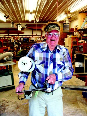 Don Kramer is shown here with the E-Z Ditcher in his home workshop where he invented the tool.