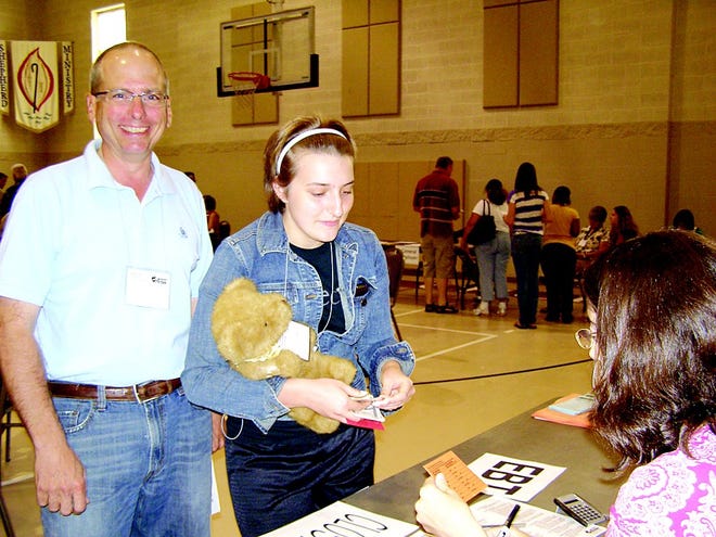 Bill Kirkpatrick, Fayetteville and formerly of Greencastle, and Ariana Heim portray young siblings buying food during a Poverty Simulation. The teddy bear was an infant, and could not be left unattended during the event.