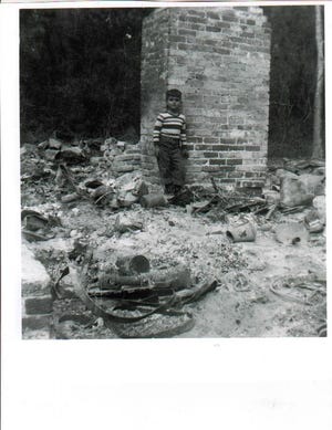 The Crane Island home of Sarah Alice Broadbent the morning after fire destroyed it in 1952. The young boy pictured is Nick Deonas, who later became a Nassau County commissioner.
