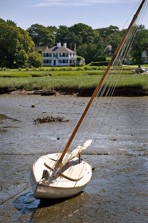 A sailboat has nowhere to go during low tide along the Bluefish River in Duxbury.