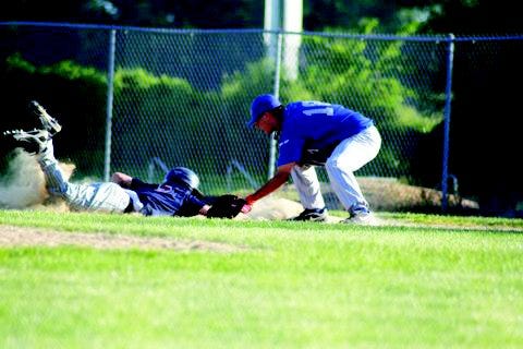 Alex Temple dives in under the tag on a pickoff attempt during Post 136's game with East Moline.