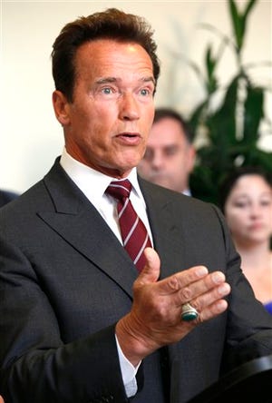 In this June 9, 2010 file photo, California Gov Arnold Schwarzenegger speaks at news conference to applaud the passage of Proposition 14 in Los Angeles. Schwarzenegger's order to pay 200,000 state workers just the minimum wage sent a signal to California lawmakers: In the impasse over closing California's $19 billion budget deficit, the governor is ready to play hardball.