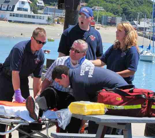 Hull firefighter John Lombardo helps a man injured when the Spirit of Massachusetts struck a shoal off Deer Island in Boston Harbor on Saturday, July 3, 2010. Assisting areScituate emergency medical technician Donna McGrath and Scituate firefighter Tim Callahan.
