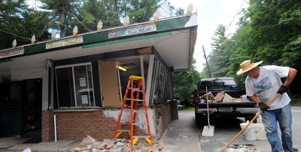 Jeff Helms of Wooddale, a regular customer of Mary Ann's Dairy Bar in Analomink, helps clean up the rubble on Friday following an accident Thursday night. A vehicle left route 191 while travelling south and dislodged two steel barricades and struck the corner of the local landmark. Owner Michelle Hooey said that the shop will be open as soon as possible and will remain open while reconstruction is underway.
