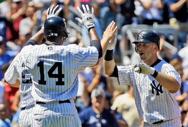 New York's Brett Gardner, right, celebrates with teammates Curtis Granderson, center, and Chad Huffman, right, blocked from view, after hitting a grand slam in the third inning on Saturday afternoon against Toronto in New York.