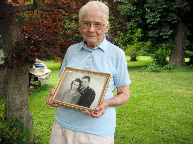 In This June 25, 2010 photo, Jean Stevens, 91, holds a photograph from the 1940s of herself and her late husband, James, outside her home in Wyalusing, Pa. Authorities say Stevens stored the bodies of her husband, who died in 1999, and her twin, who died in October 2009, on her property. As state police finish their investigation into a singularly macabre case, no charges have been filed, Stevens wishes she could be reunited with James Stevens, her husband of nearly 60 years, and June Stevens, her twin. But their bodies are with the Bradford County coroner now, off-limits to the woman who loved them best.