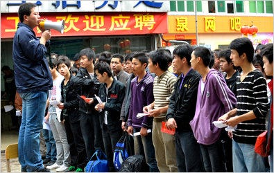 A recruiter from Foxconn Technology speaking to job applicants outside a company factory in China’s Guangdong Province.