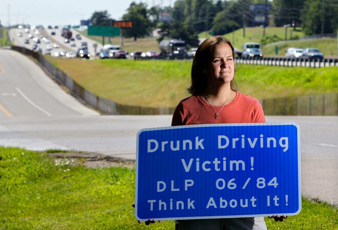 Gail Rehme holds a highway sign on Thursday that for the next 10 years will mark a stretch of Interstate 270 in St. Louis County where her brother, David Poenicke, was killed 26 years ago by a drunken driver.